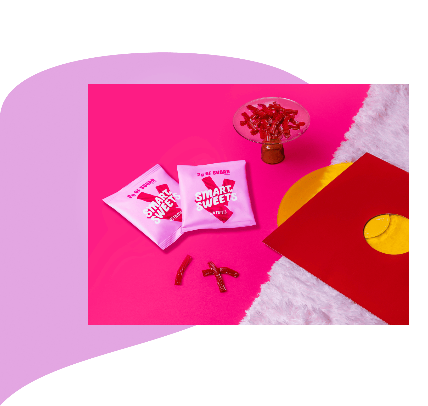 Two Red Twists pouches on a pink surface