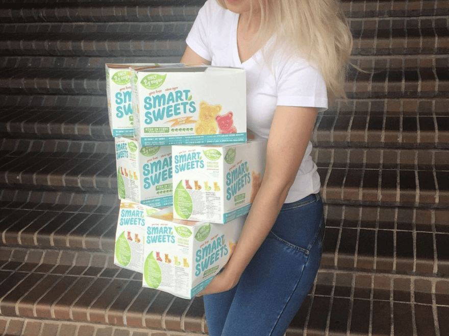 Founder Tara holding old SmartSweets boxes