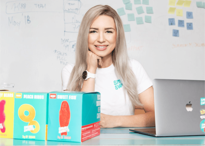Founder Tara with SmartSweets boxes in the bottom left corner