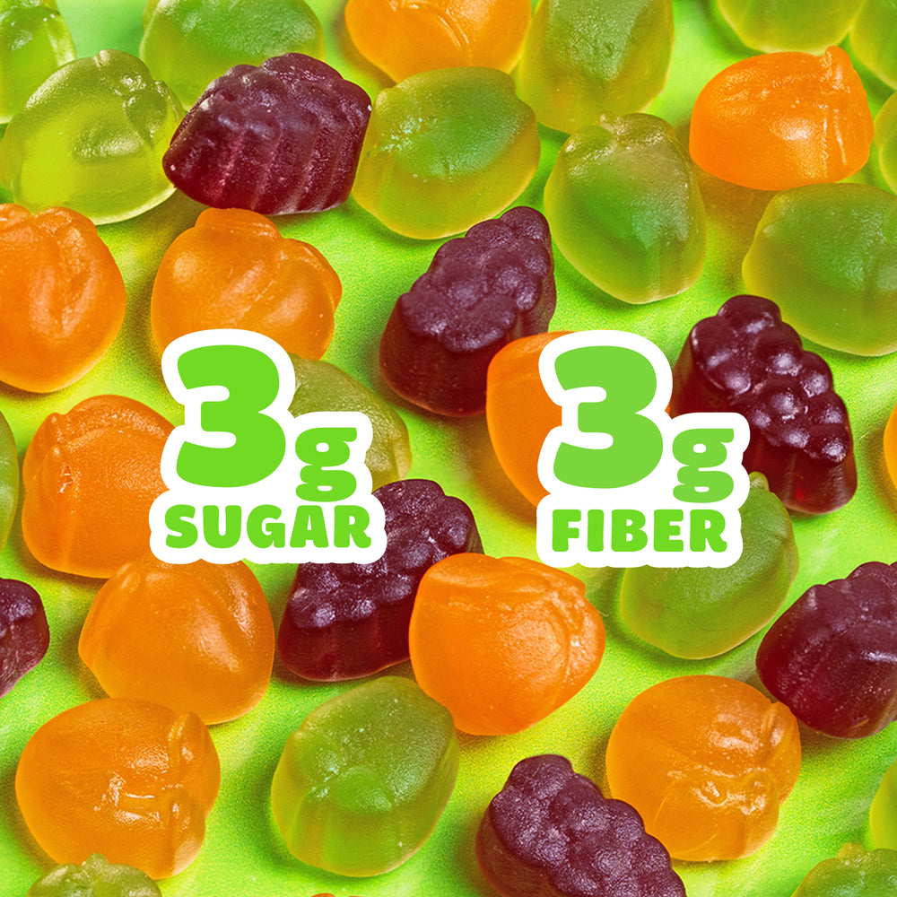 Assorted fruit gummies on green background. Text: 3g SUGAR, 3g FIBER.