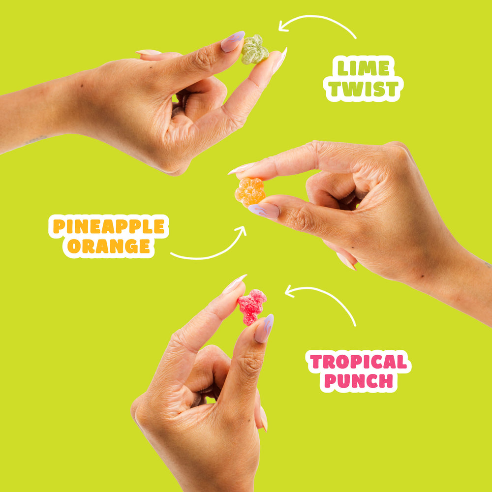 Three tropical sour gummy candies on a green background labeled with white arrows: Lime Twist, Pineapple Orange, and Tropical Punch.